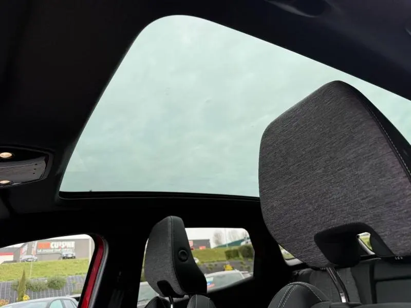 Vue intérieure du toit panoramique du Renault Austral Rouge Flamme 2025, avec appuie-tête avant en tissu gris.