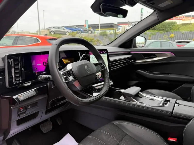 Vue intérieure côté conducteur du Renault Austral 2025, avec tableau de bord numérique et éclairage d'ambiance violet.
