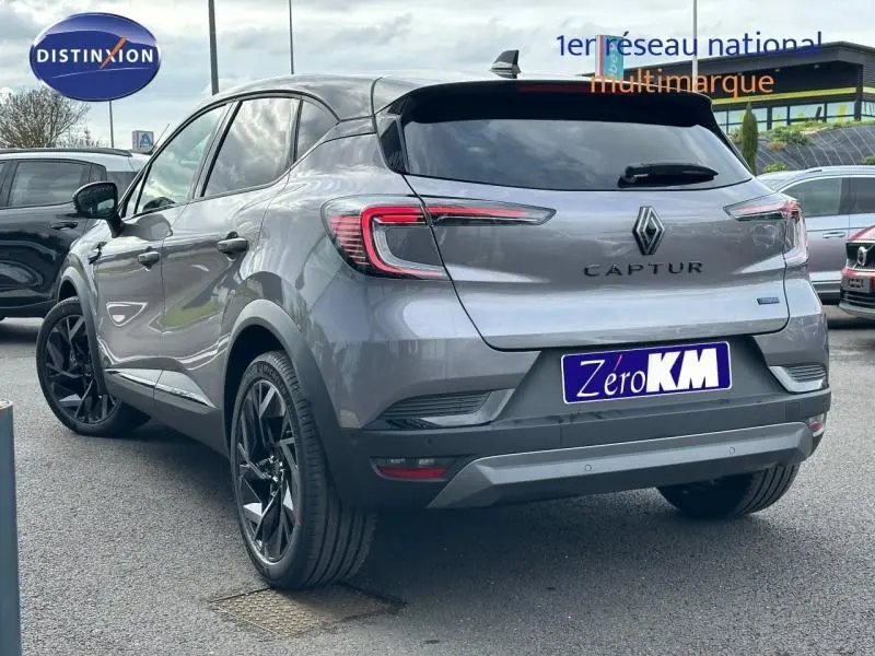 Vue 3/4 arrière du Renault Captur 2026 gris Cassiopée avec toit noir étoilé et jantes noires distinctives.