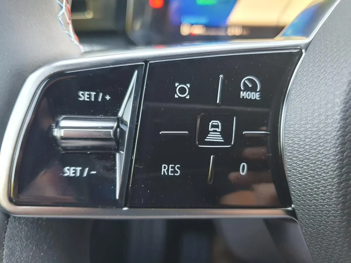 Gros plan sur les commandes de régulateur de vitesse au volant d’une Renault Clio VI hybride.