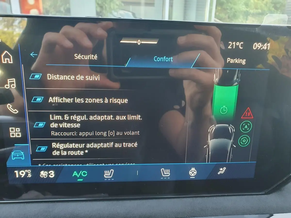 Écran tactile intérieur de la Renault Clio VI affichant les réglages de sécurité et confort, avec interface moderne.