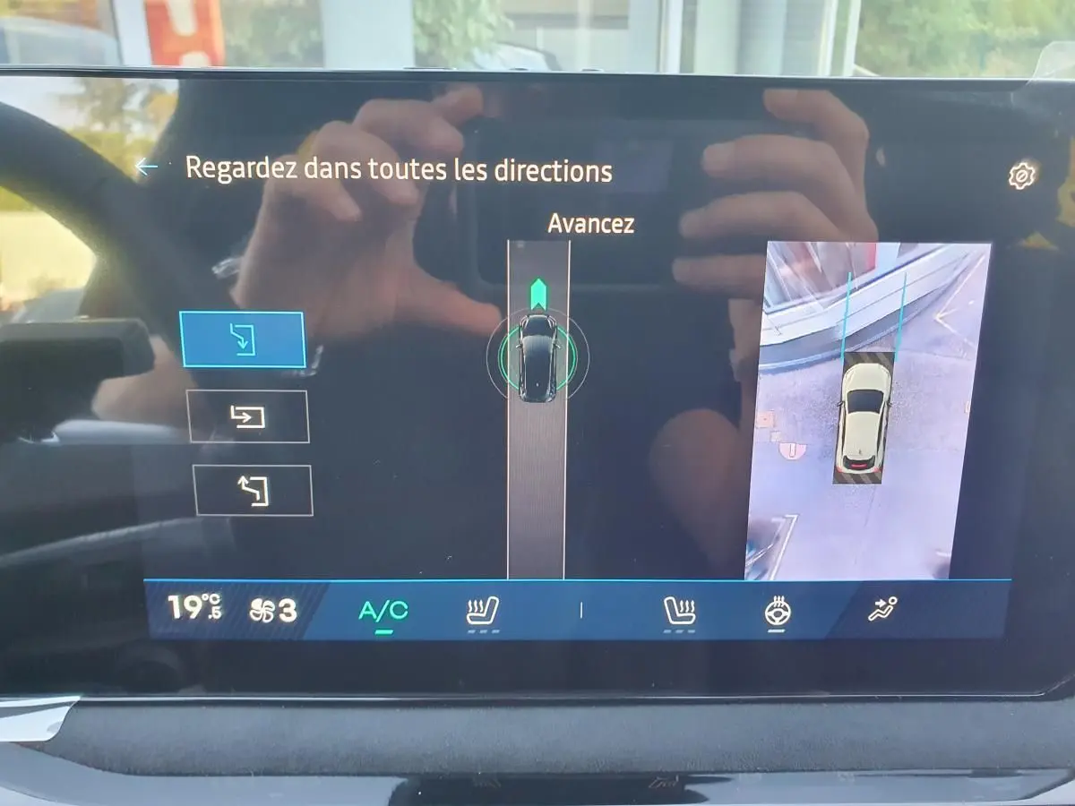 Écran tactile intérieur montrant la caméra de recul et l’aide au stationnement de la Renault Clio VI rouge Absolu.