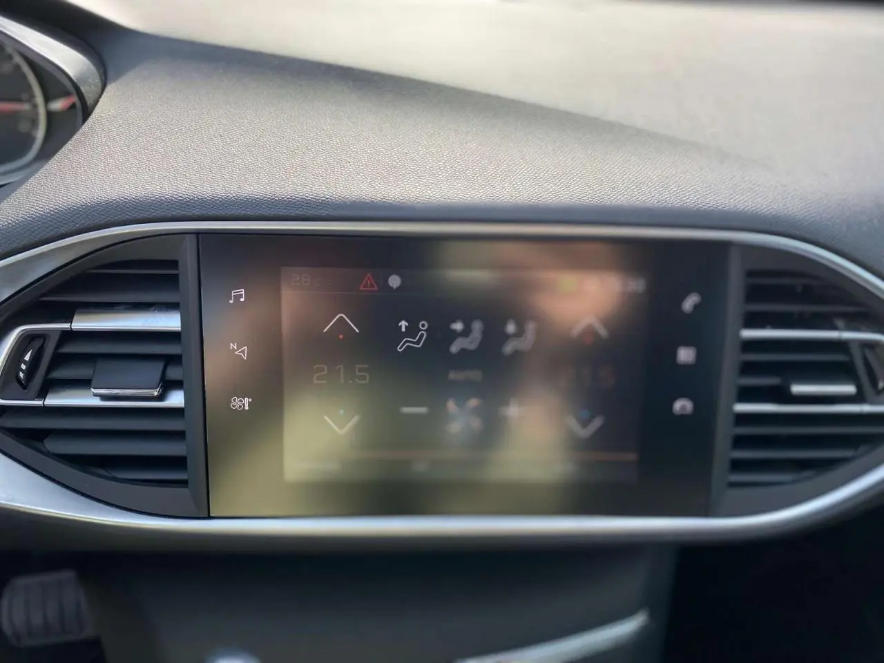 Écran tactile central du tableau de bord de la Peugeot 308 SW gris Artense, affichant la climatisation automatique bi-zone.