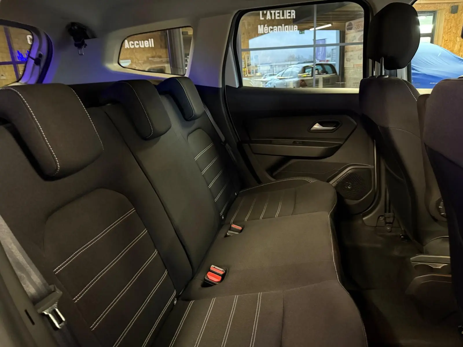 Vue intérieure côté droit des sièges arrière noirs avec surpiqûres blanches du Dacia Duster gris 2019 Prestige.