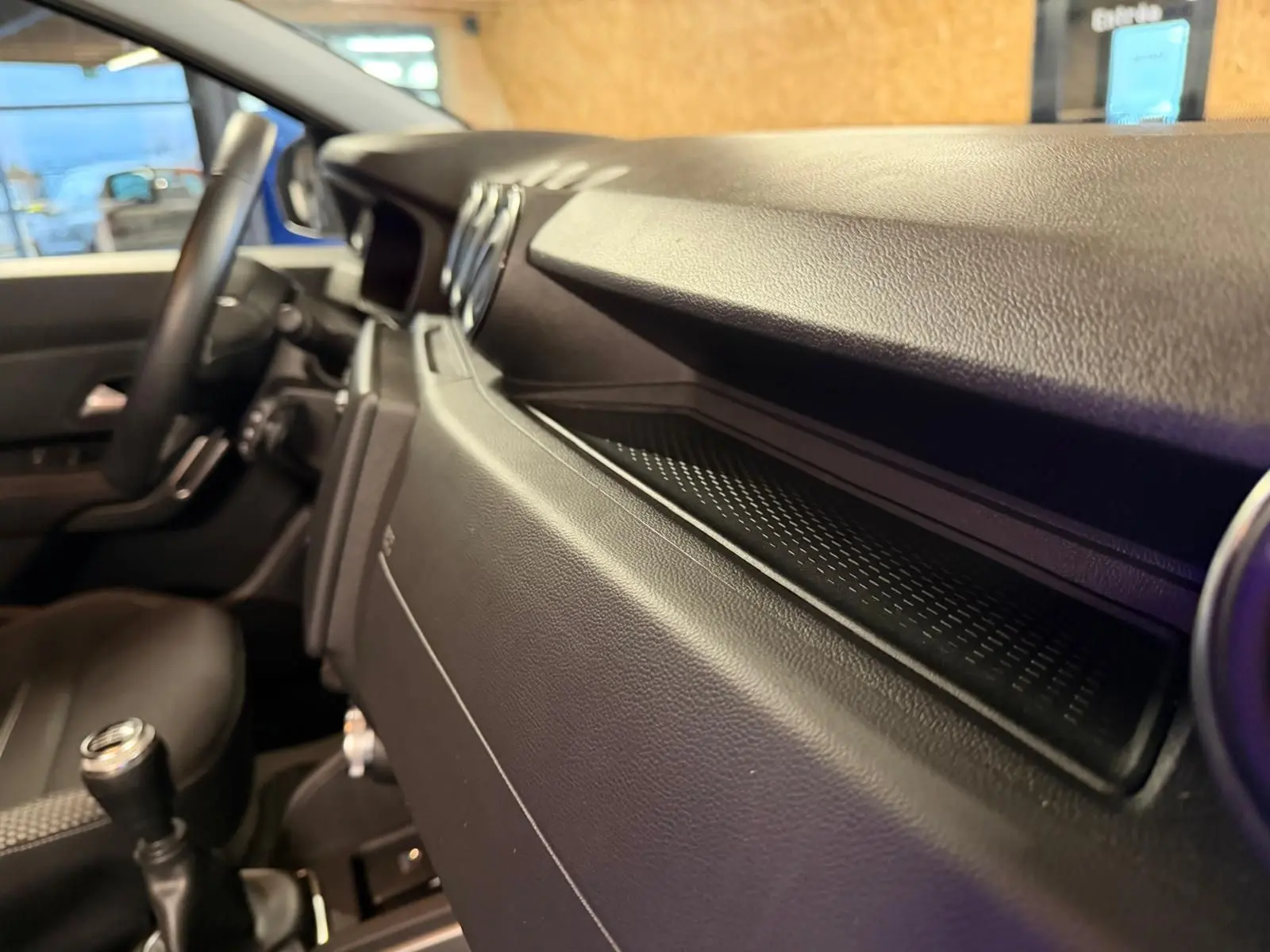 Intérieur du Dacia Duster gris 2019, vue côté passager sur tableau de bord et volant avec levier de vitesse manuel.