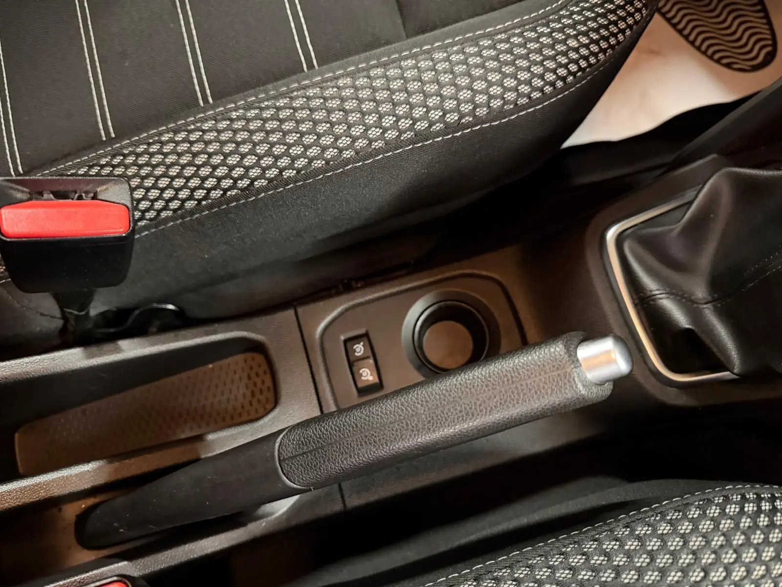 Vue rapprochée du frein à main et levier de vitesse manuel dans l'habitacle tissu noir du Dacia Duster gris 2019.