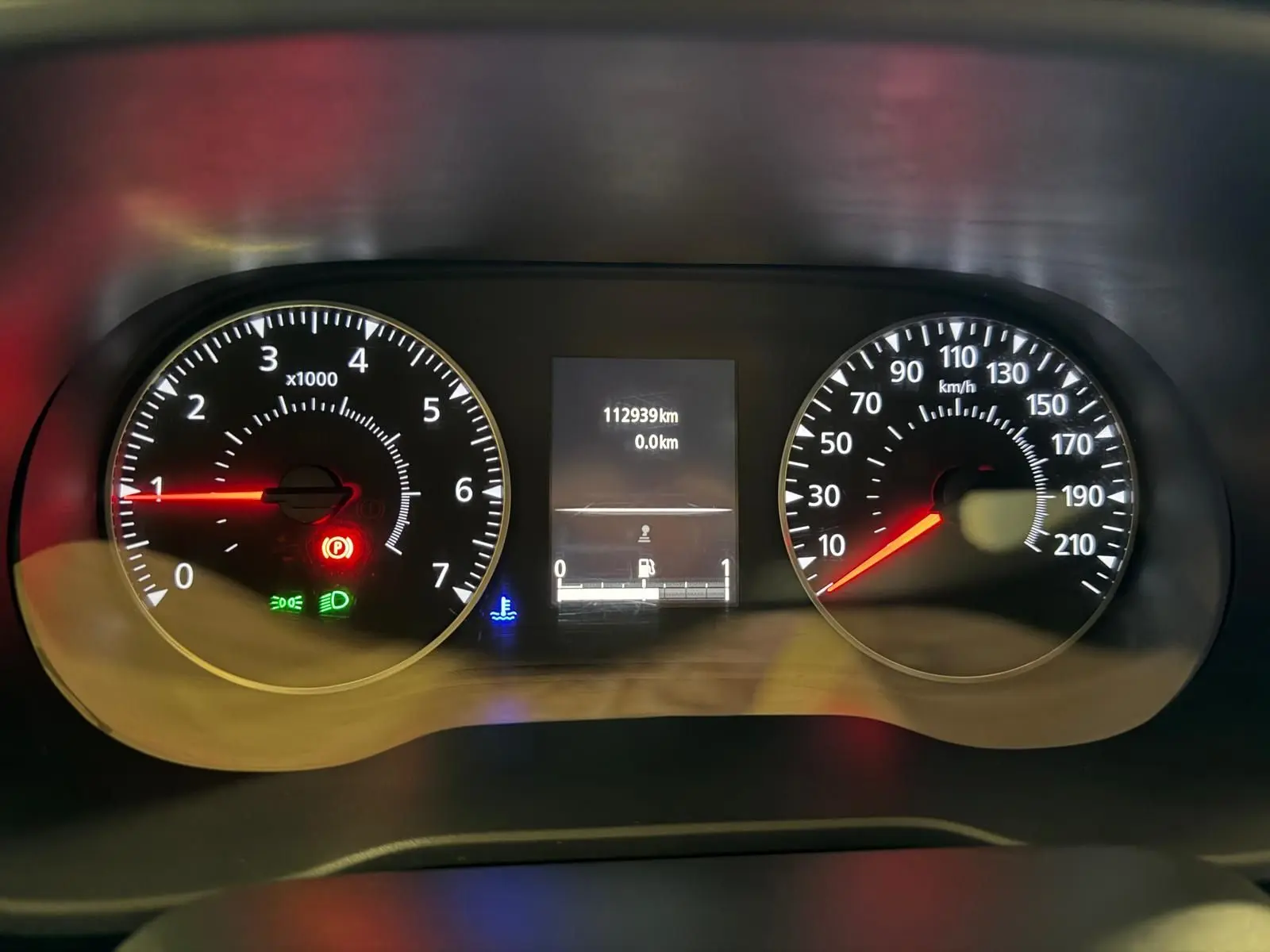 Gros plan sur le tableau de bord du Dacia Duster gris, affichant le compteur de vitesse et le compte-tours allumés.