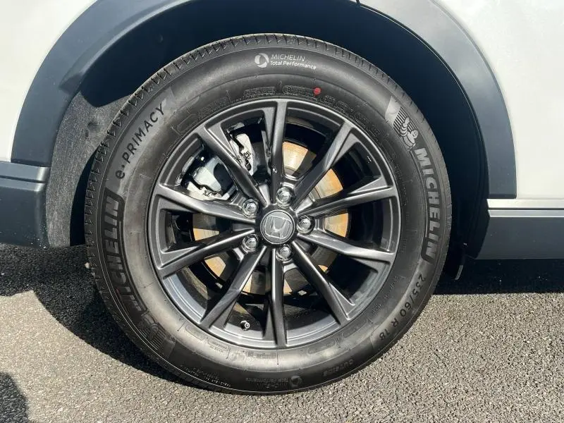 Gros plan sur la roue avant droite du Honda CR-V 2024 avec jante alliage noire et pneu Michelin e-Primacy.