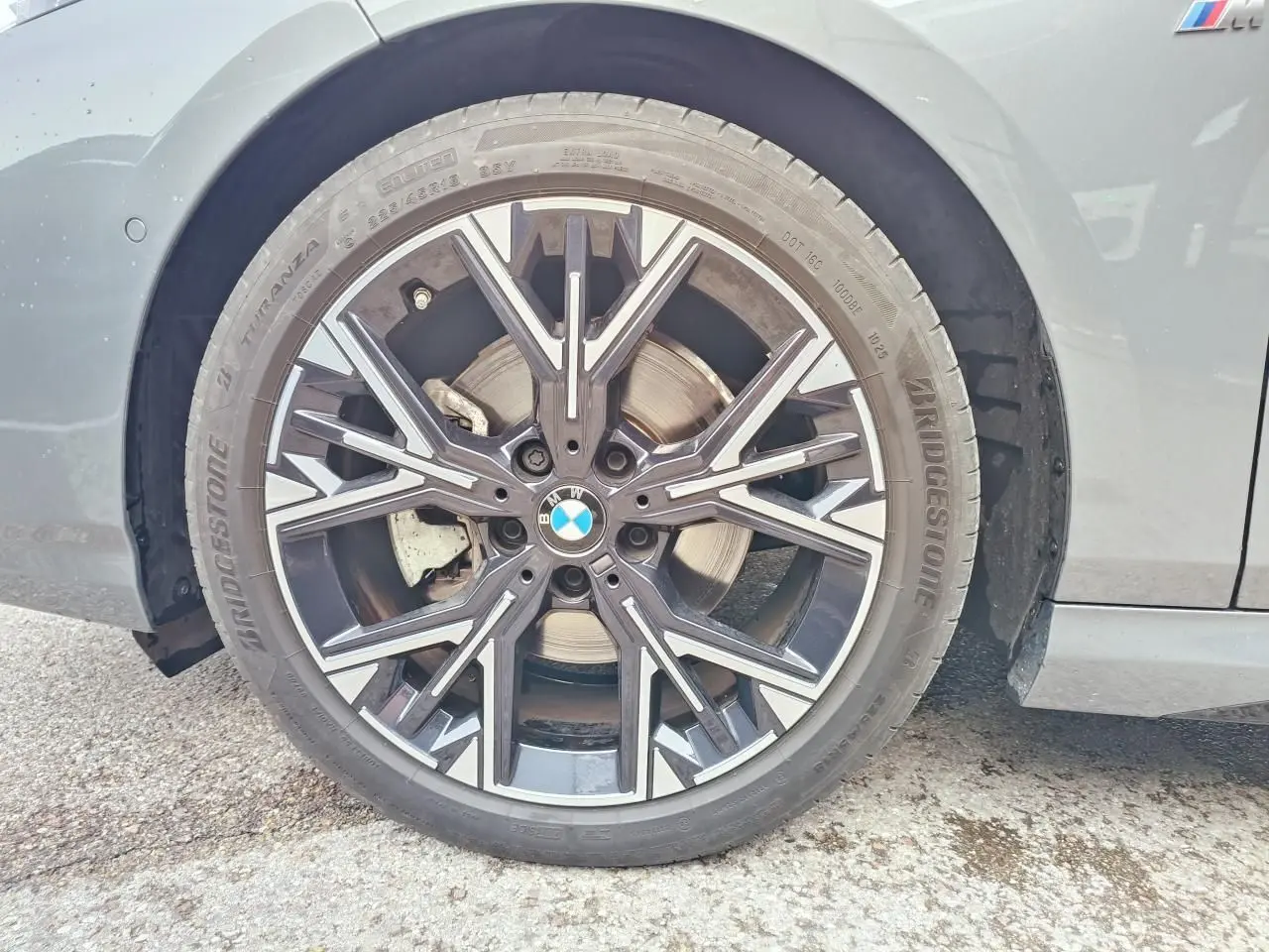 Gros plan sur la roue avant droite de la BMW Série 1 gris Skyscraper avec jante alliage M bicolore et logo BMW au centre.