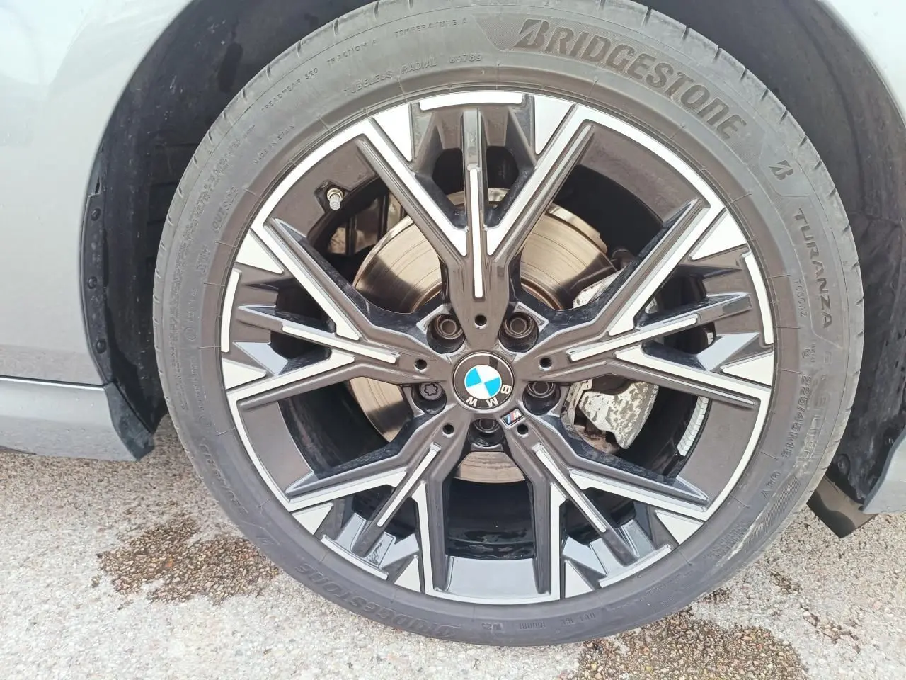 Gros plan sur la jante avant droite noire et argentée de la BMW Série 1 F70 gris Skyscraper.