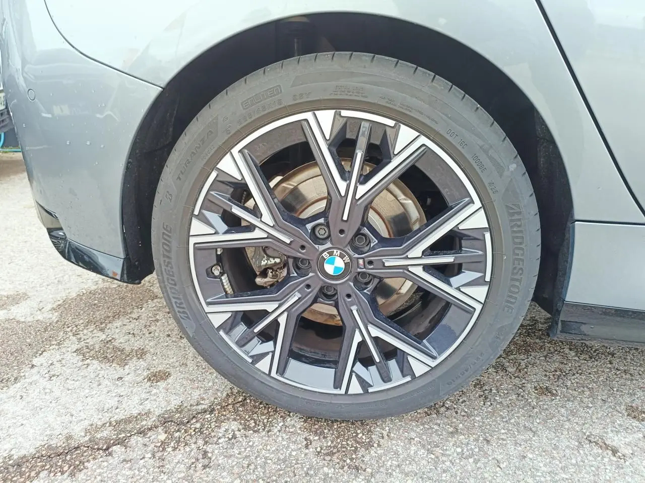 Gros plan sur la jante avant droite bicolore noire et argentée d'une BMW Série 1 gris Skyscraper.