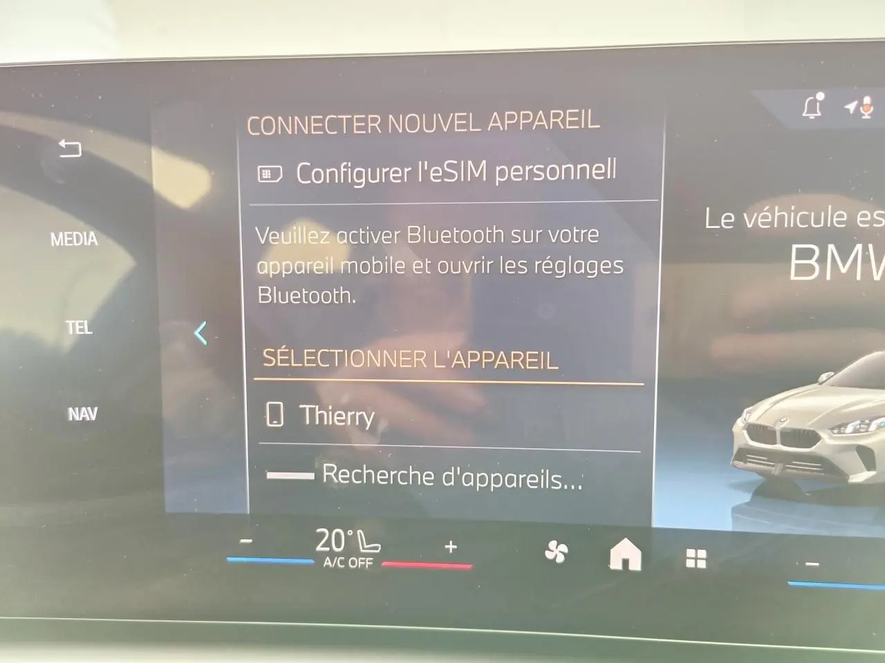 Écran tactile du système BMW Live Cockpit affichant la connexion Bluetooth et une image de BMW Série 1 gris Skyscraper en 3/4 avant droit.