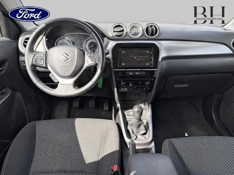 Vue intérieure frontale du Suzuki Vitara 2019 avec volant cuir, boîte manuelle et écran tactile central.