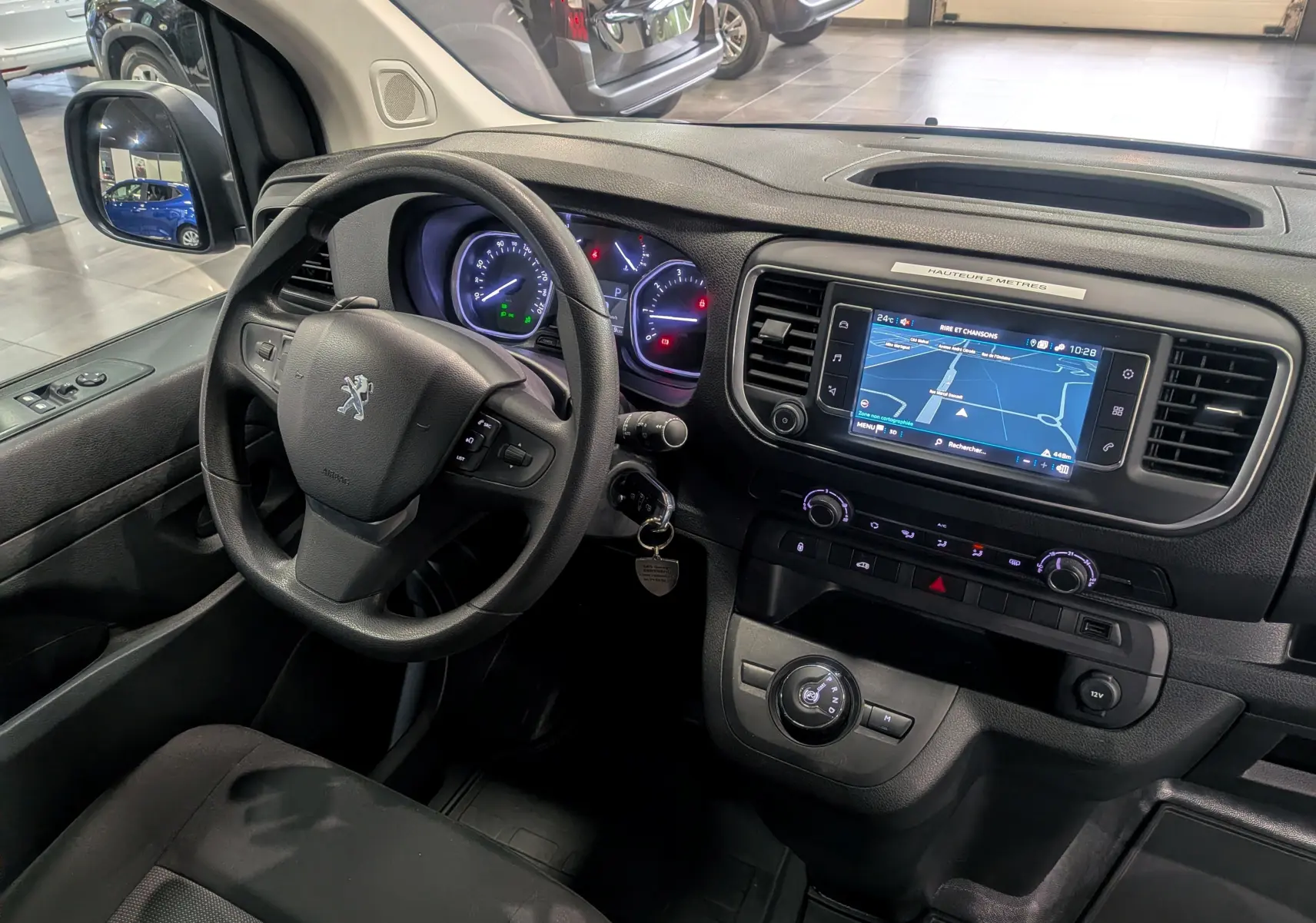 Vue intérieure côté conducteur du Peugeot Expert Fourgon 2023, tableau de bord avec écran tactile et volant noir.