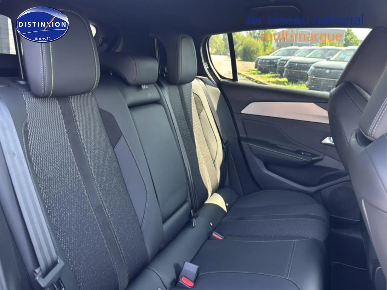 Vue latérale droite de l'intérieur arrière gris foncé de la Peugeot 308 1.2 hybrid 145 GT e-DCS6 avec sièges en tissu et cuir.