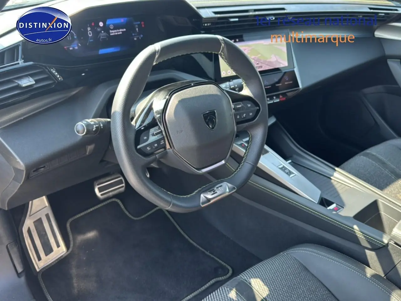 Vue intérieure côté conducteur du Peugeot 308 gris 2025, avec volant multifonction et écran tactile central.