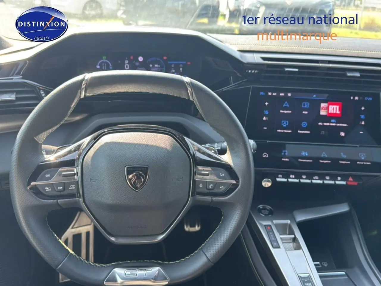 Vue intérieure centrée sur le volant cuir noir GT et l'écran tactile du tableau de bord d'une Peugeot 308 gris 2025.