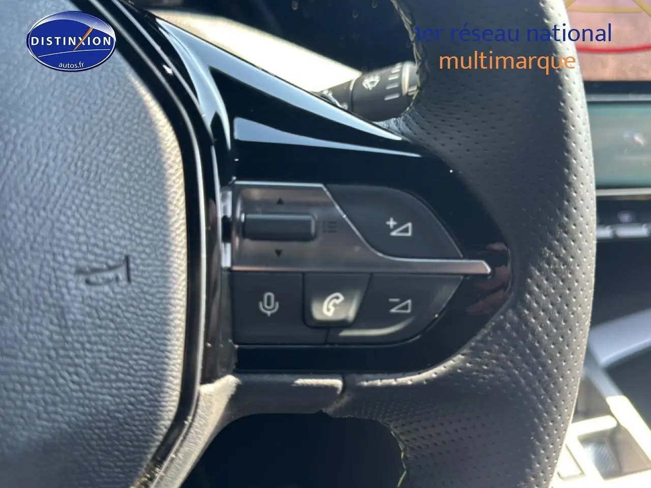 Gros plan sur les commandes vocales et téléphone du volant perforé noir d'une Peugeot 308 gris 1.2 hybrid 145 GT e-DCS6 2025.