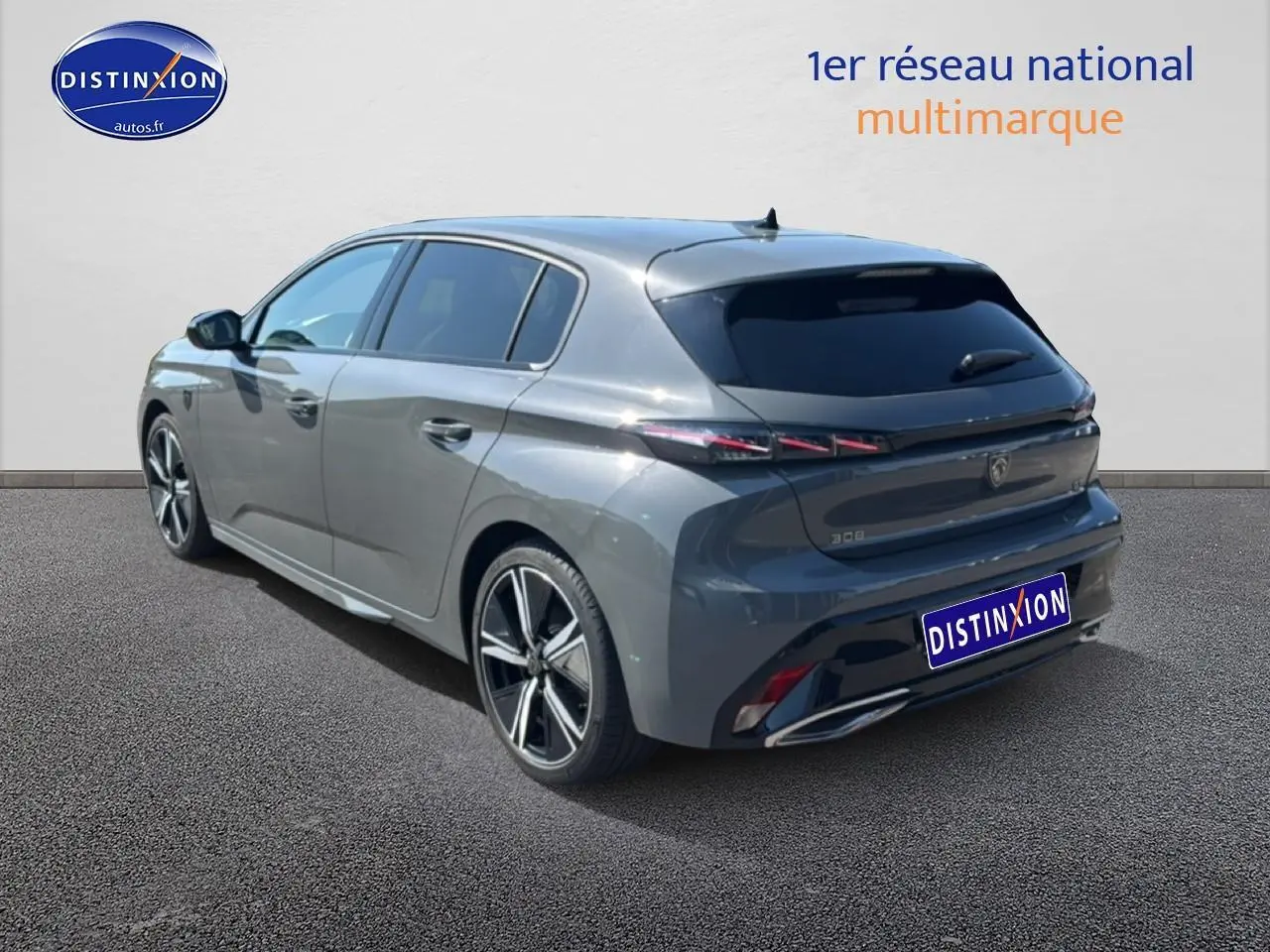 Peugeot 308 gris métallisé vue 3/4 arrière droit, jantes alliage et feux arrière LED distinctifs.
