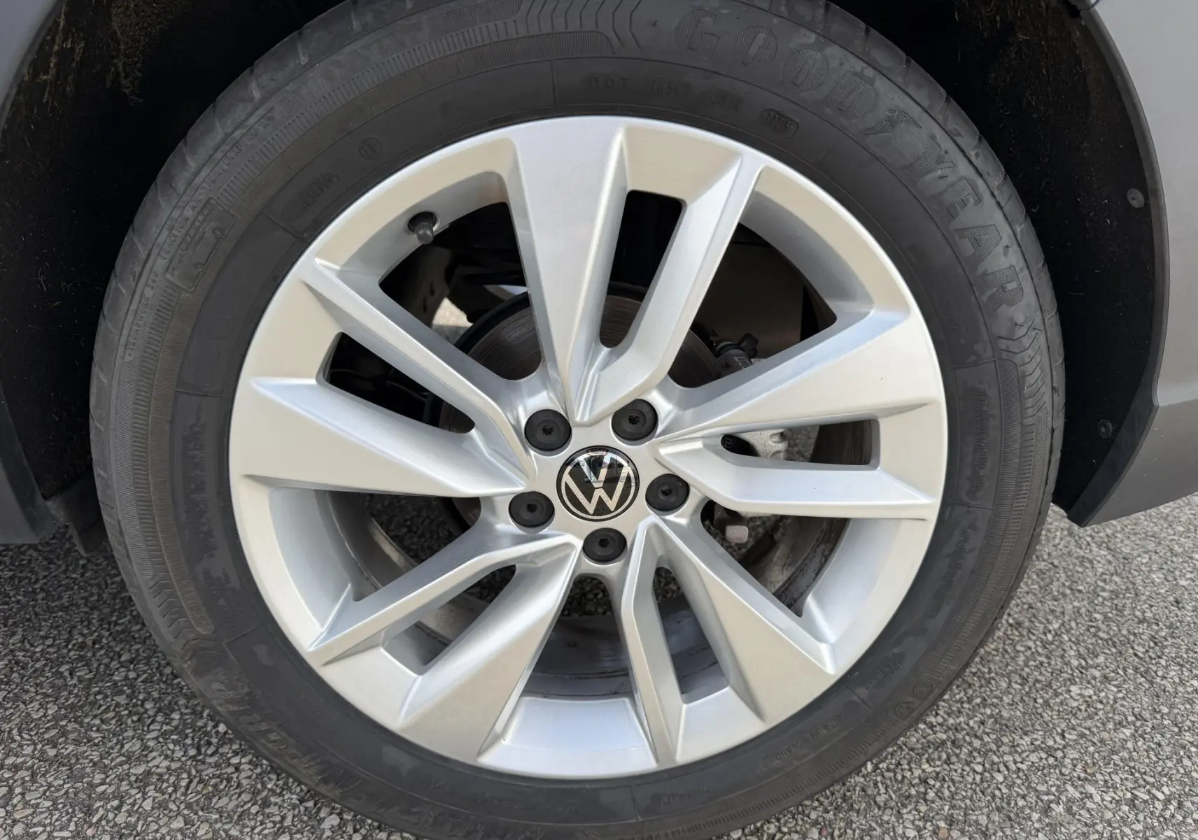 Gros plan sur la jante alliage 17 pouces Bangalore argentée du Volkswagen Taigo bleu, avec logo VW au centre.