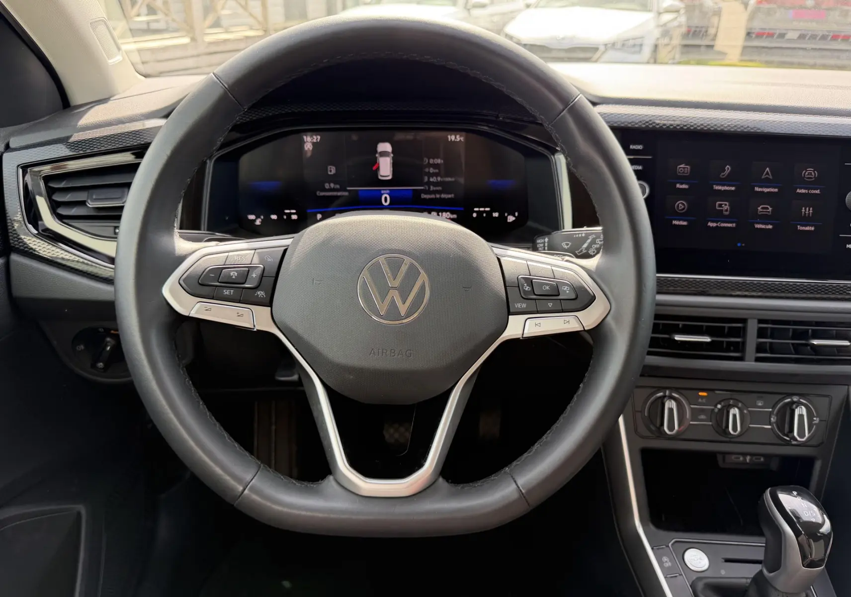 Vue intérieure centrée sur le volant cuir multifonctions et le tableau de bord digital du Volkswagen Taigo 2025.