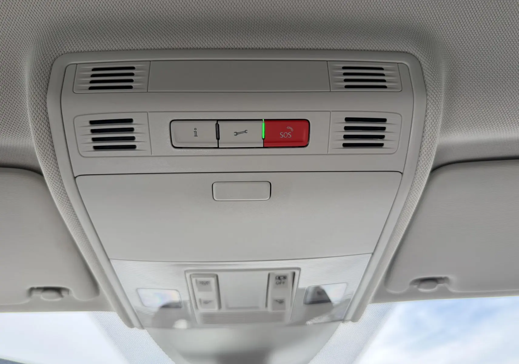 Plafonnier intérieur avec boutons SOS et éclairage, vue en contre-plongée dans un Volkswagen Taigo bleu.