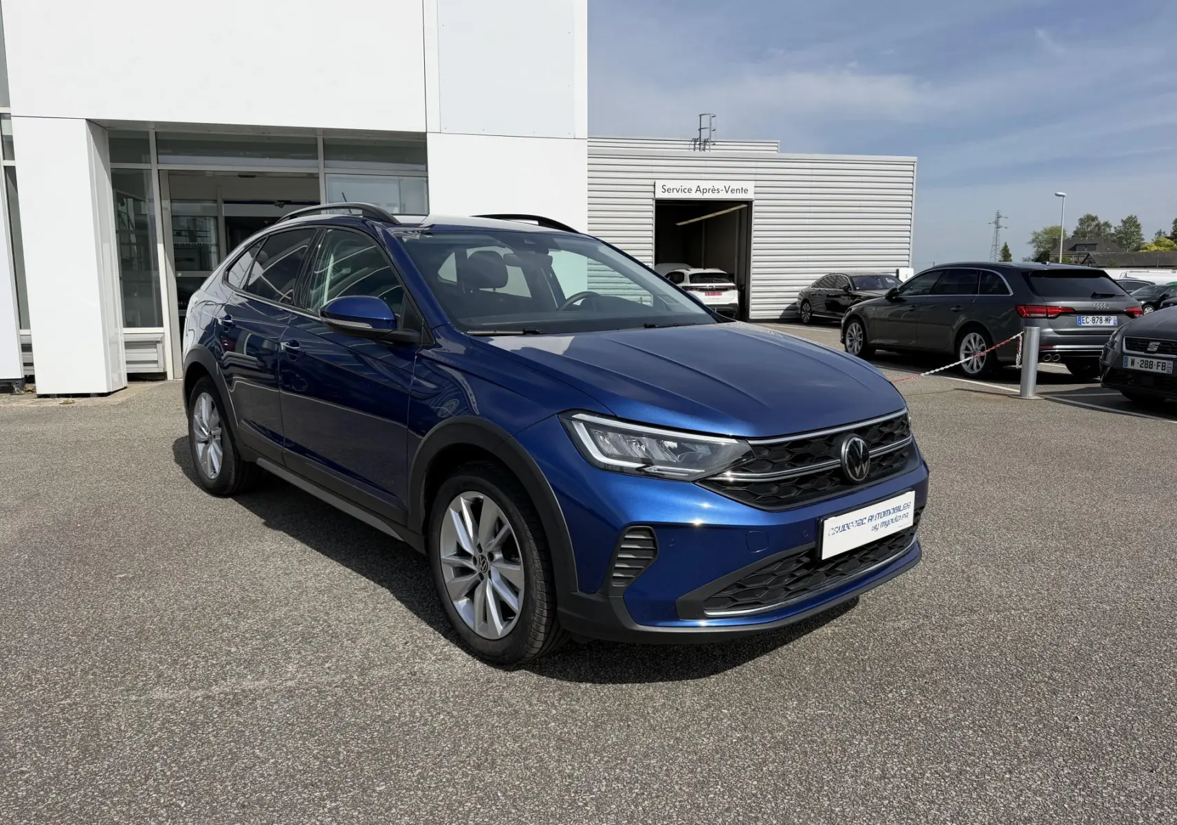 Volkswagen Taigo bleu métallisé en 3/4 avant droit, avec jantes alliage et calandre noire distinctive.