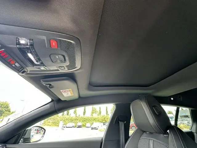 Vue intérieure du toit ouvrant panoramique et du siège avant droit en tissu noir de la Peugeot 508 SW gris 2020.