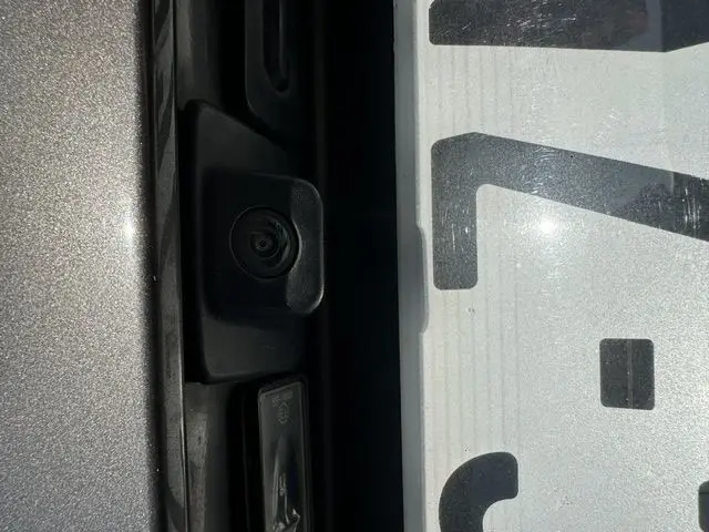 Gros plan sur la caméra de recul intégrée à l'arrière gris métallisé du Peugeot 508 SW 2020, près de la plaque d'immatriculation.