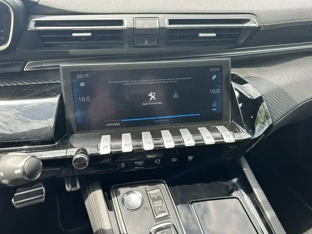 Vue rapprochée de la console centrale et écran tactile du Peugeot 508 SW gris, avec commandes piano et finition carbone.