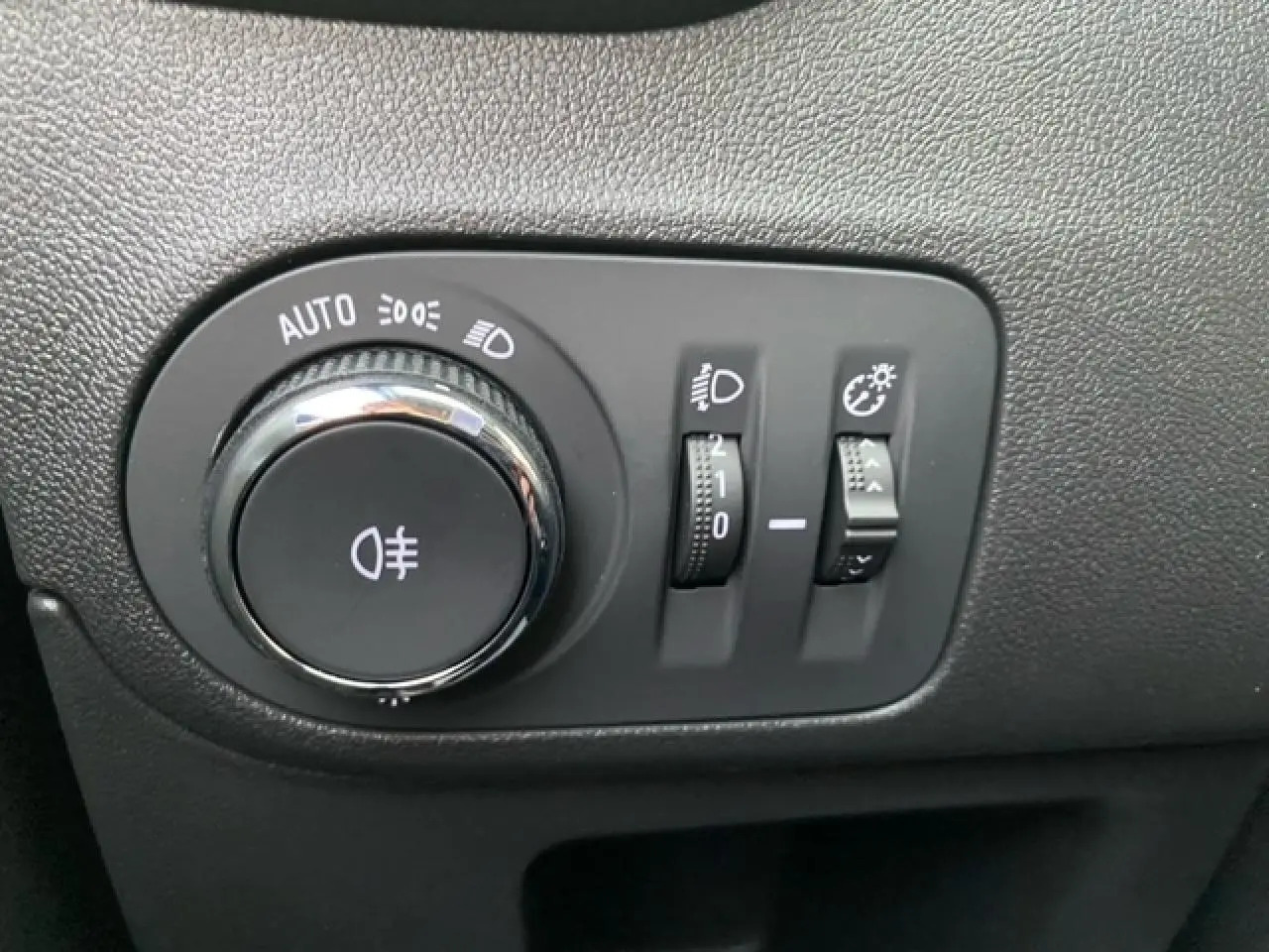 Gros plan sur les commandes d’éclairage intérieures de l’Opel Crossland gris alu, avec réglages des phares et feux antibrouillard.