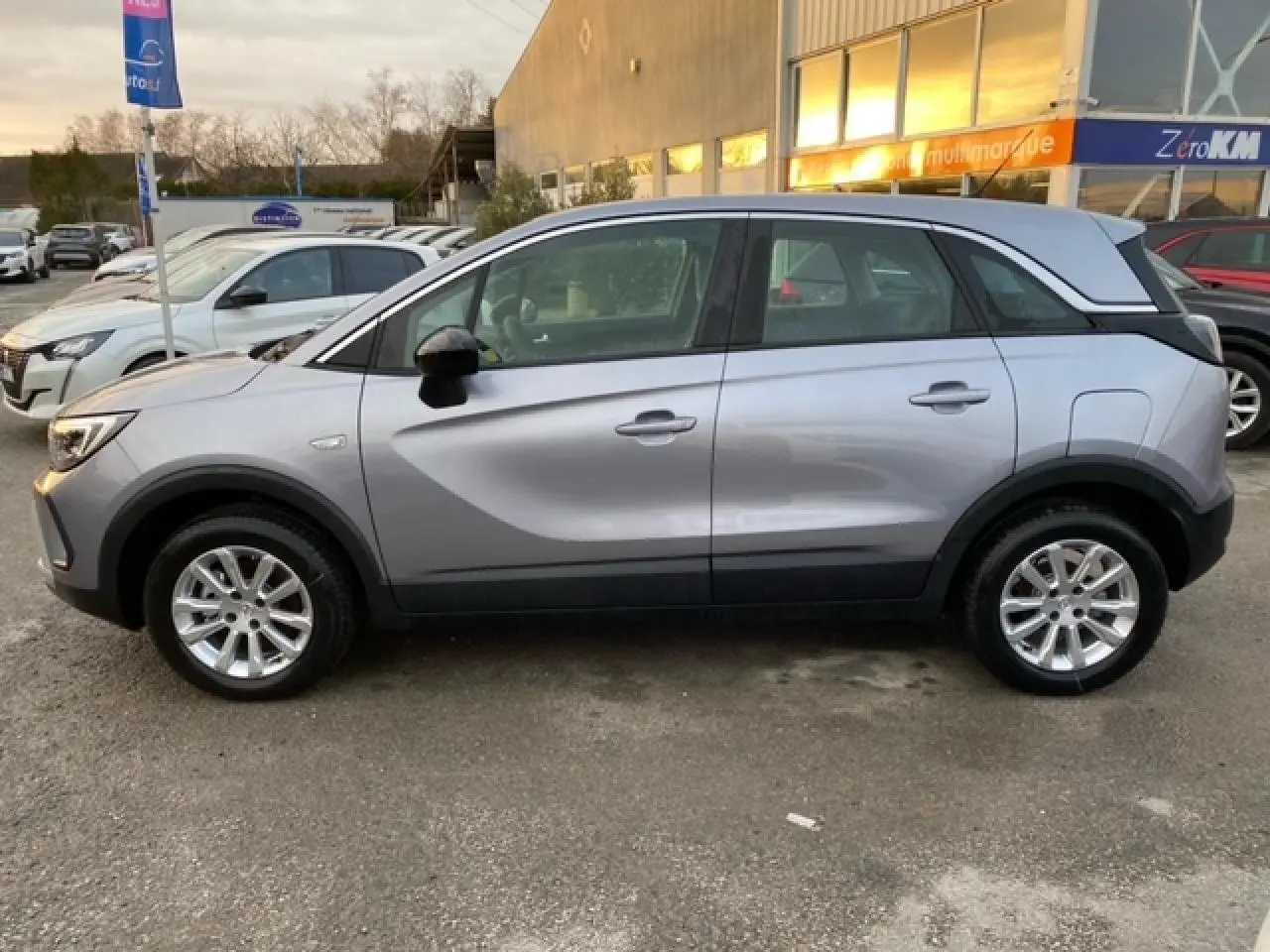 Opel Crossland gris alu vu de profil côté gauche, avec coques de rétroviseurs noires et jantes alliage 16 pouces.