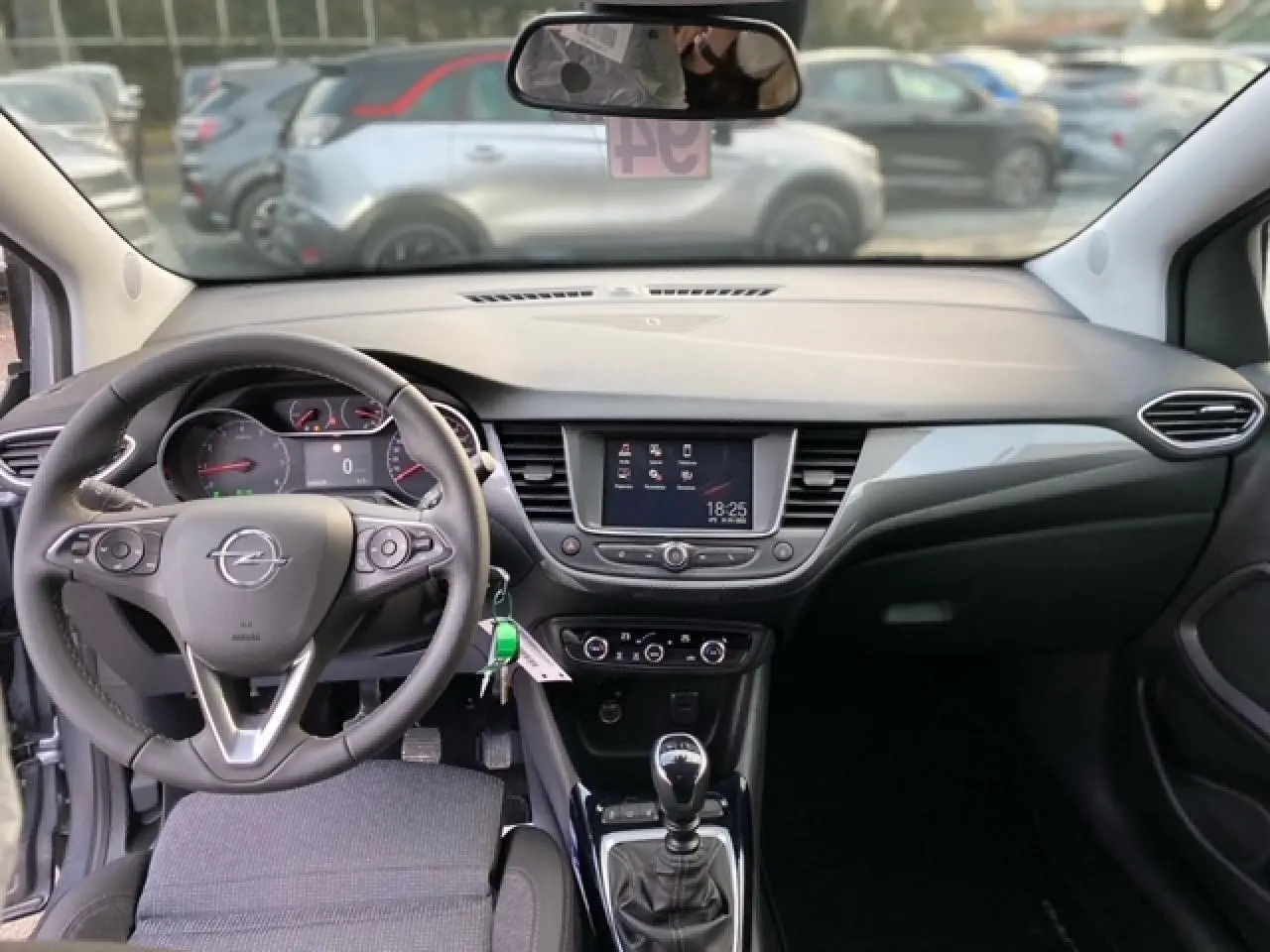 Vue intérieure de l'Opel Crossland gris alu 2022, tableau de bord moderne avec écran tactile et volant multifonction.