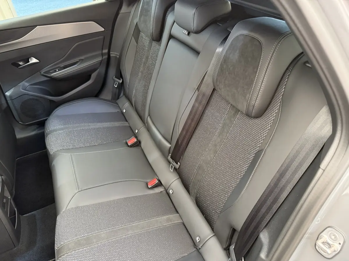 Vue côté droit de la banquette arrière gris foncé en cuir et tissu de la Peugeot 308 Hybrid 136 e-DCS6 GT 2024.