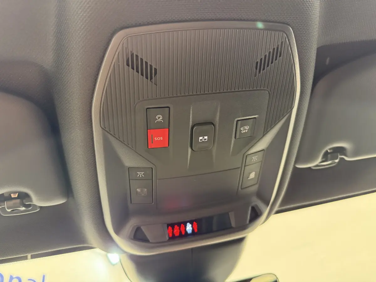 Vue en contre-plongée du panneau de commandes au plafond intérieur de la Peugeot 308 Hybrid gris foncé, avec bouton SOS rouge visible.