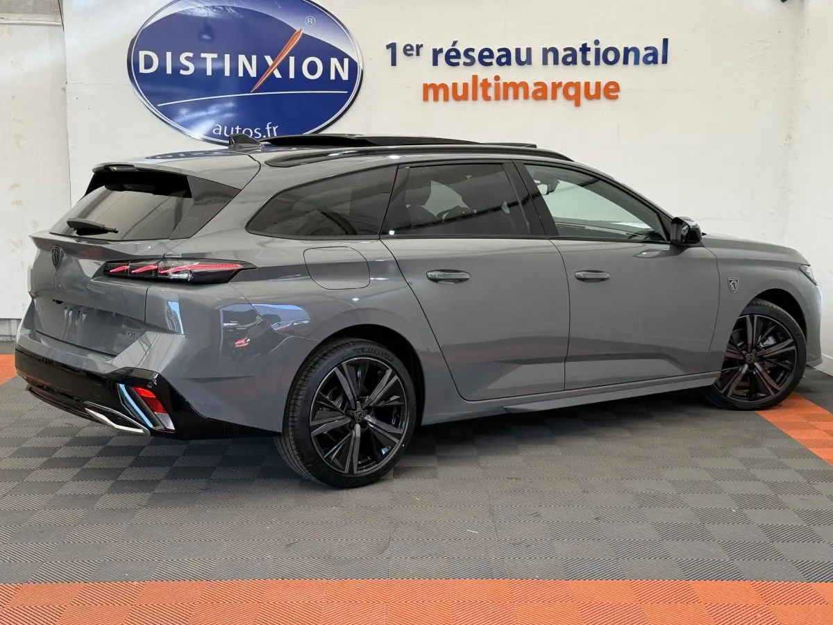 Peugeot 308 Hybrid 136 e-DCS6 GT gris foncé vue de profil côté droit, avec jantes noires et toit noir.