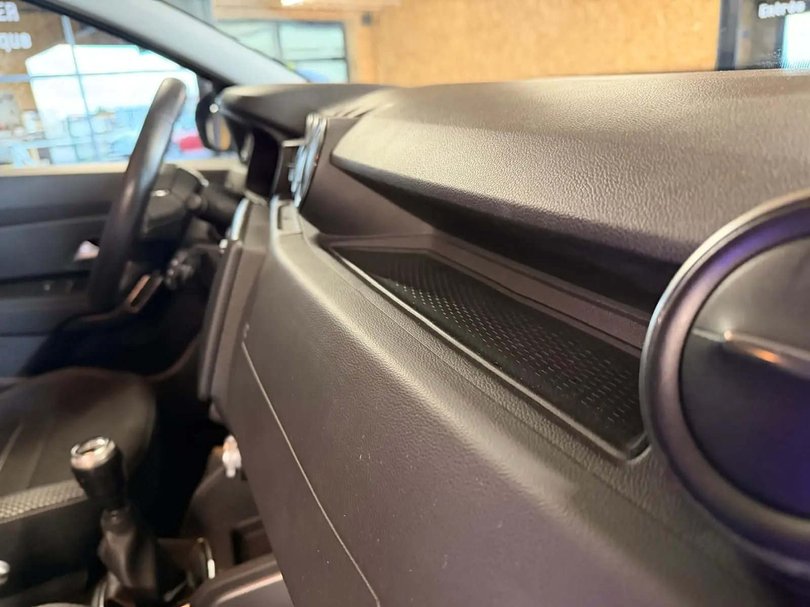 Intérieur du Dacia Duster Prestige, vue côté passager du tableau de bord et levier de vitesses manuel noir.