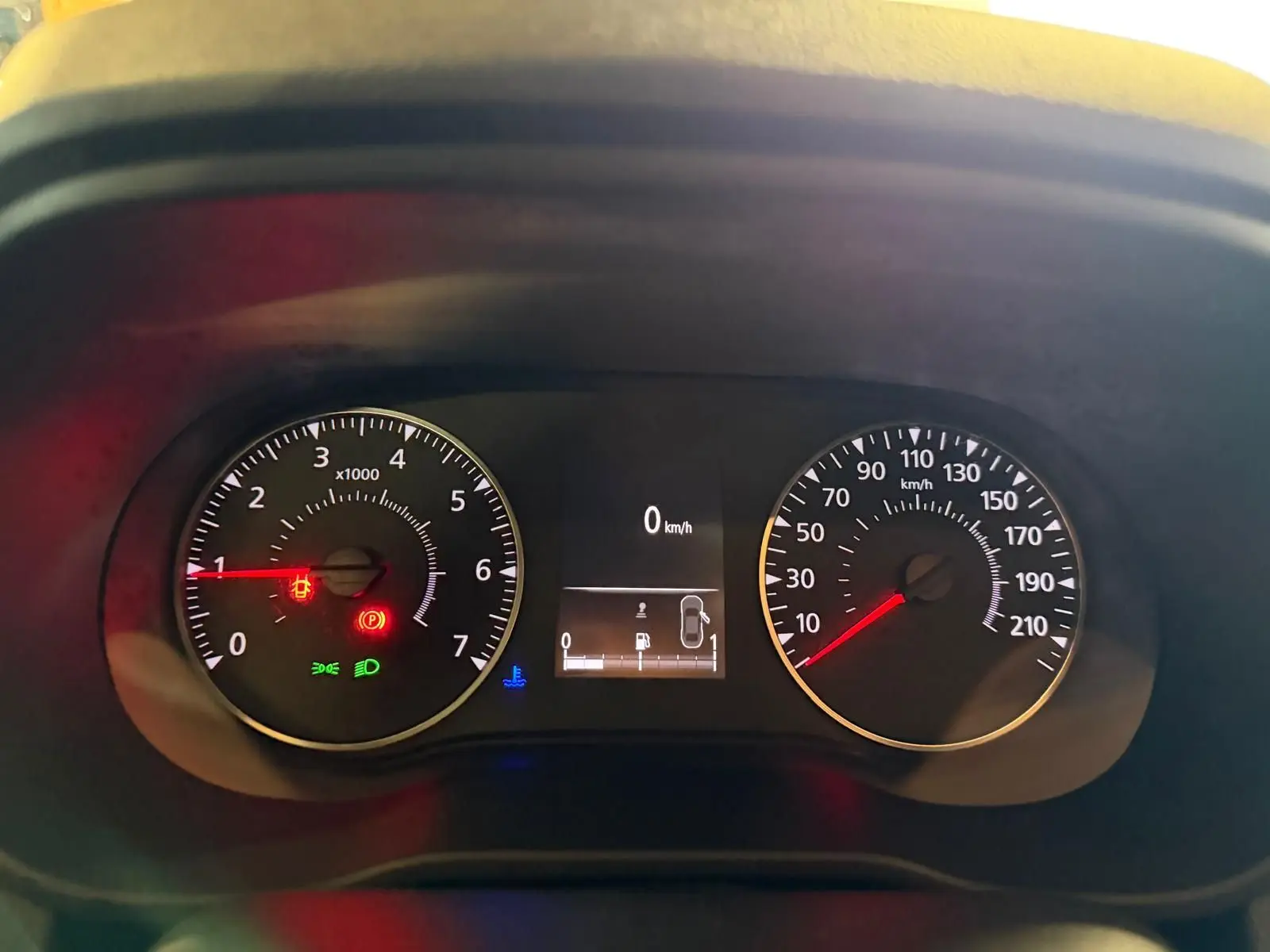 Gros plan sur le tableau de bord du Dacia Duster bleu, affichant compte-tours, vitesse et témoins lumineux actifs.