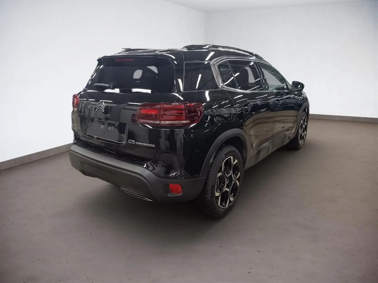 Vue 3/4 arrière droite d'un Citroën C5 Aircross Hybrid noir Perla avec jantes alliage et hayon fermé.