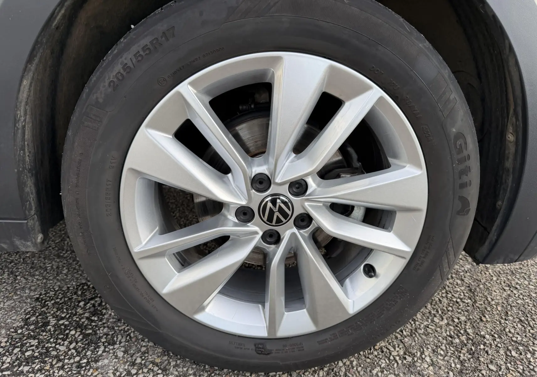 Gros plan sur la jante alliage 17 pouces Bangalore argentée du Volkswagen T-Cross gris, avec pneu 205/55 R17 visible.