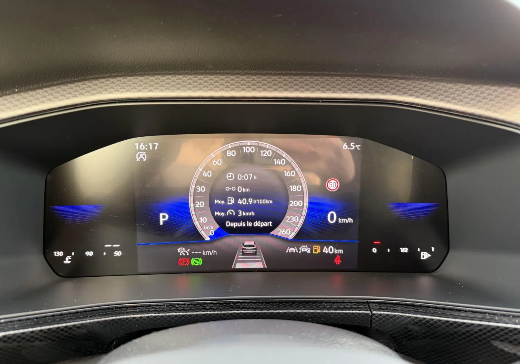 Vue rapprochée du combiné d'instruments digital du Volkswagen T-Cross gris, affichant vitesse et informations de conduite.