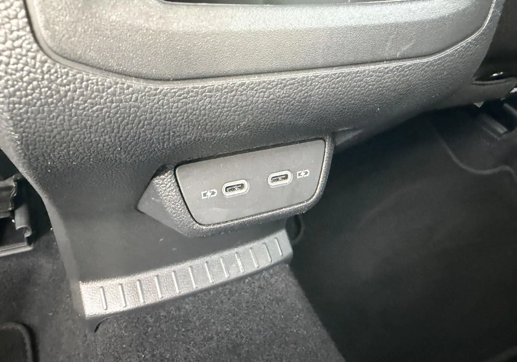 Gros plan sur les deux ports USB-C situés sous la console centrale du Volkswagen T-Cross gris.