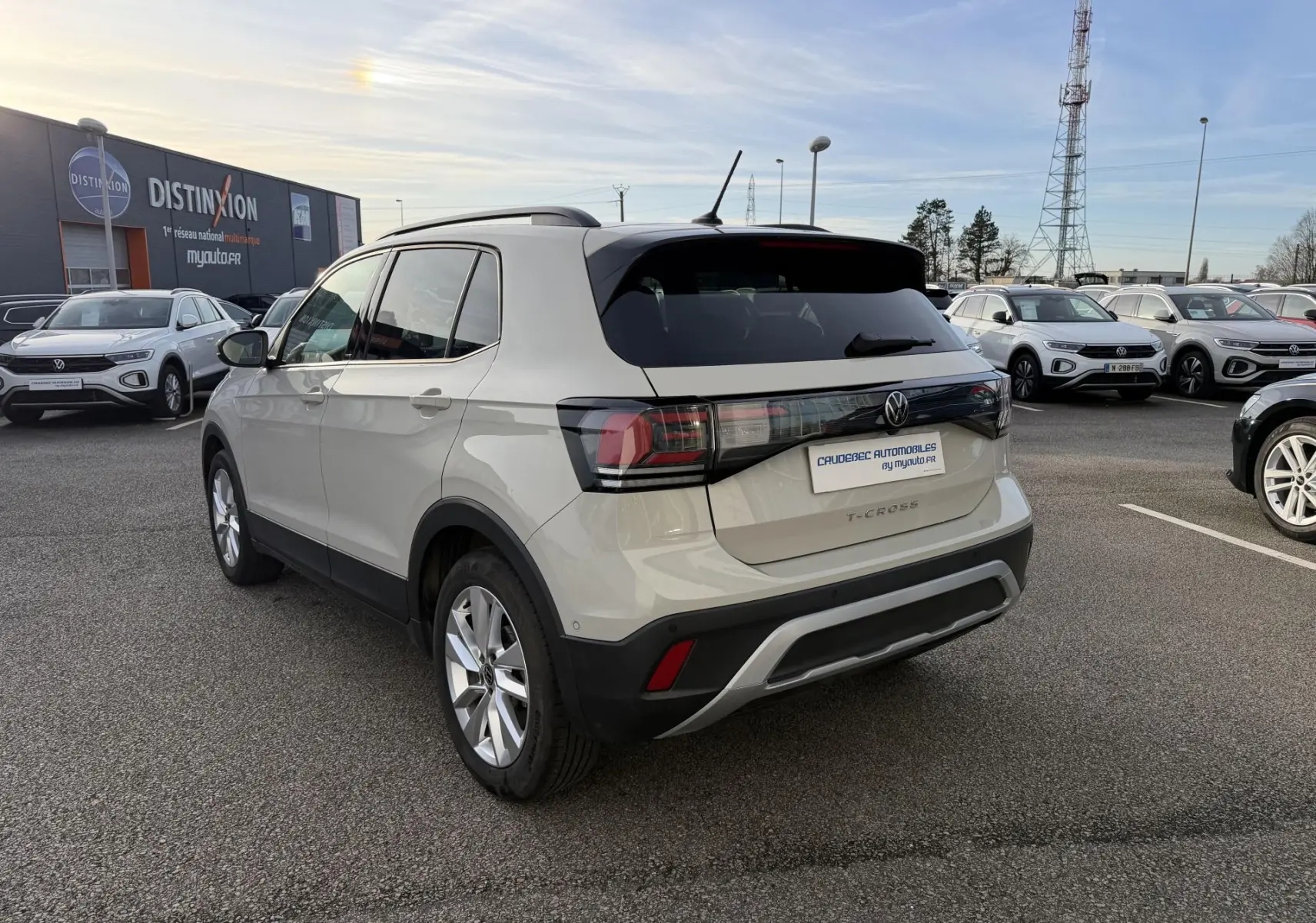 Volkswagen T-Cross gris clair vu en 3/4 arrière droit, avec toit noir et jantes alliage visibles en extérieur.