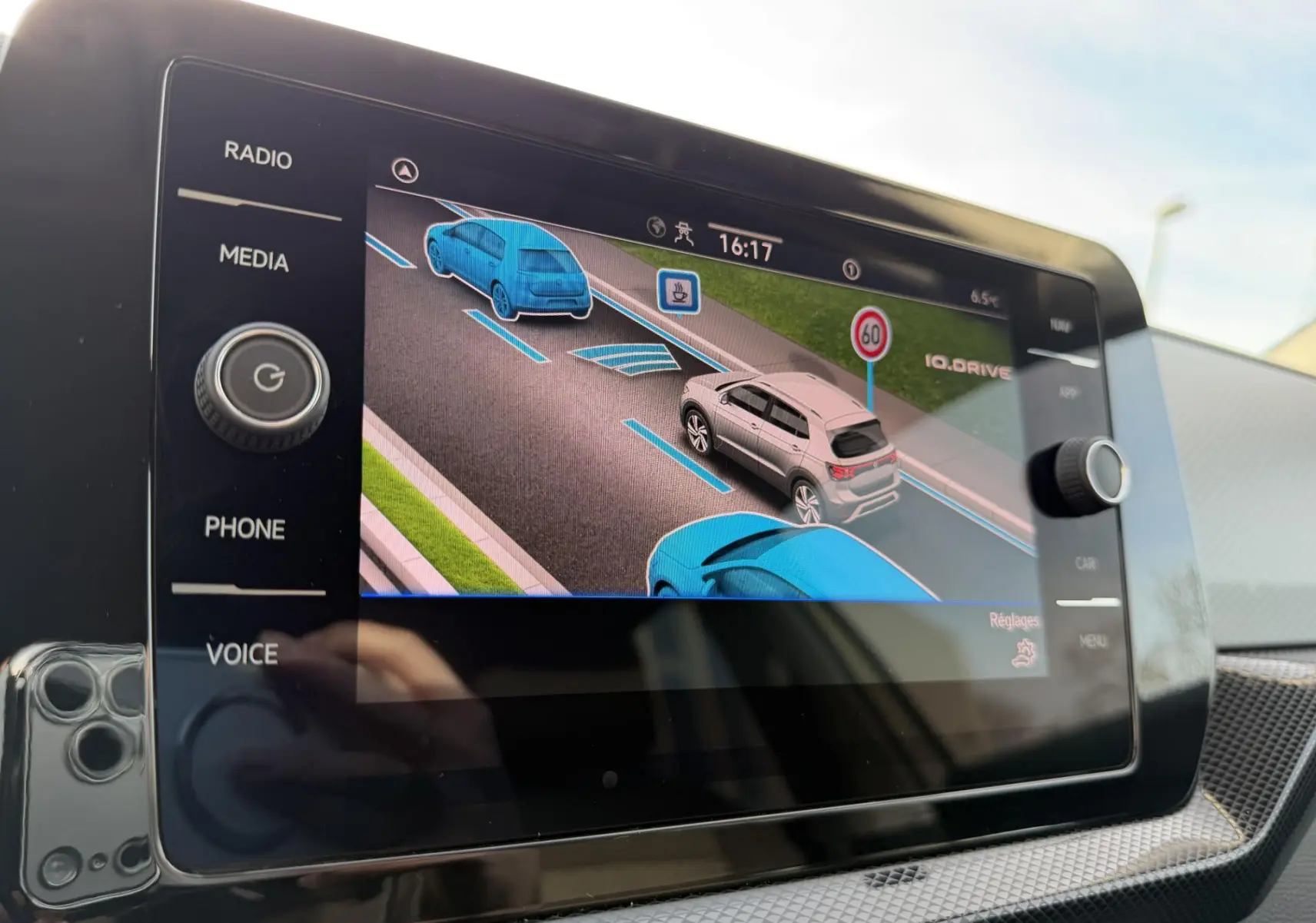 Écran tactile intérieur montrant l'aide au maintien de voie avec représentation graphique d'un Volkswagen T-Cross gris.