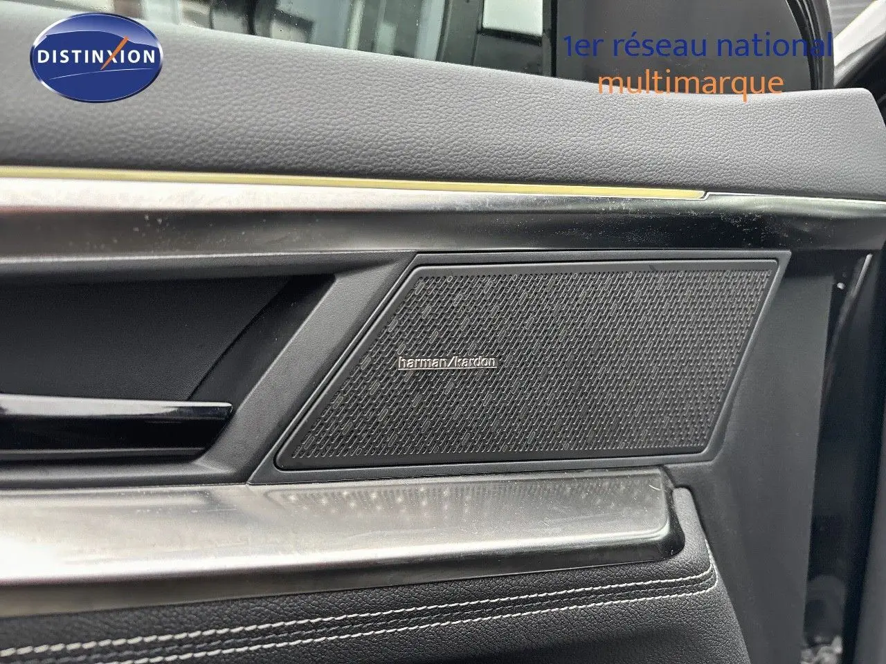 Gros plan sur la porte côté droit du Renault Austral noir étoile métal, mettant en valeur l'enceinte Harman Kardon intégrée.