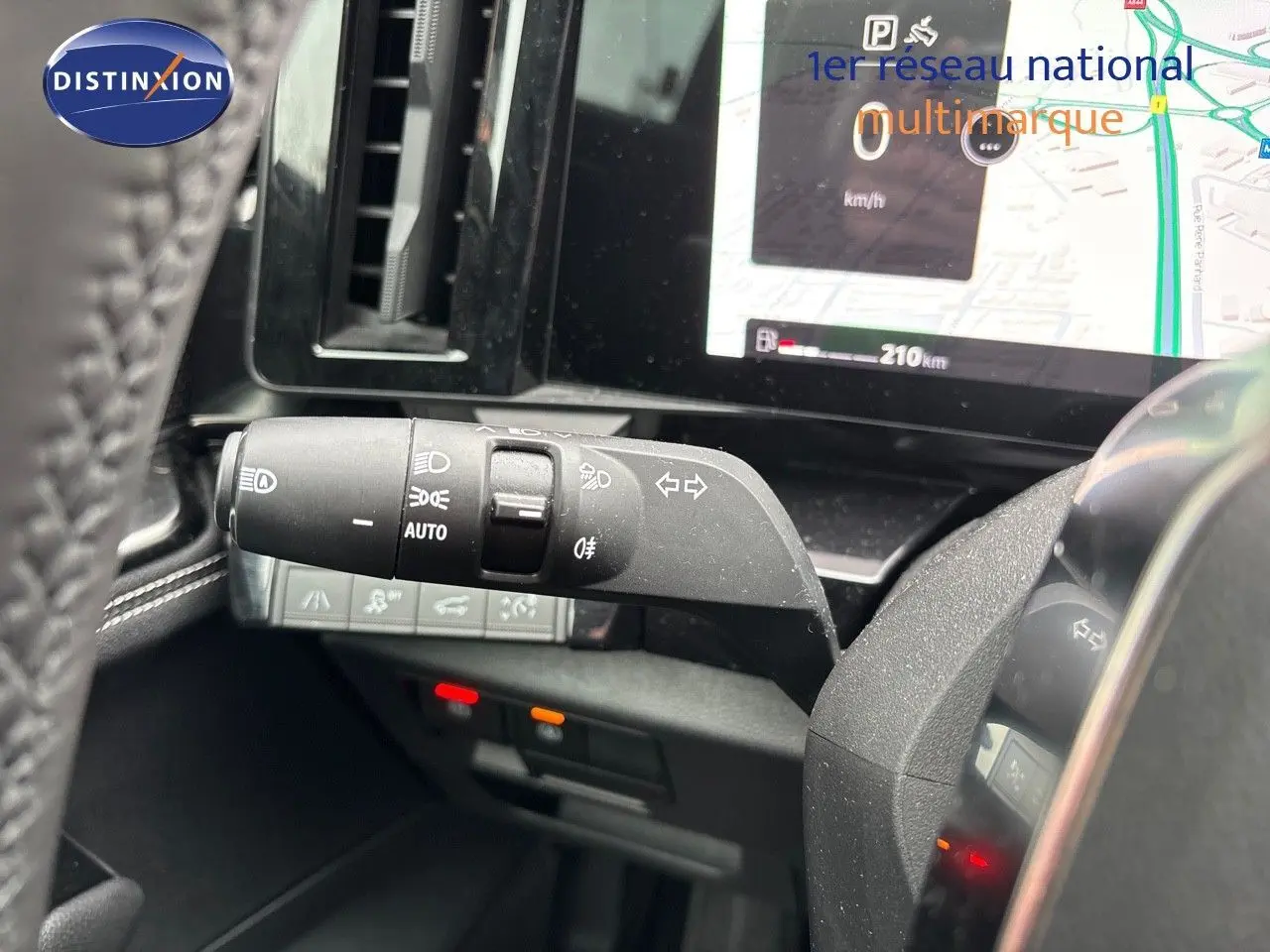 Gros plan sur la commande des feux et clignotants à gauche du volant dans le tableau de bord du Renault Austral noir étoile métal 2023.