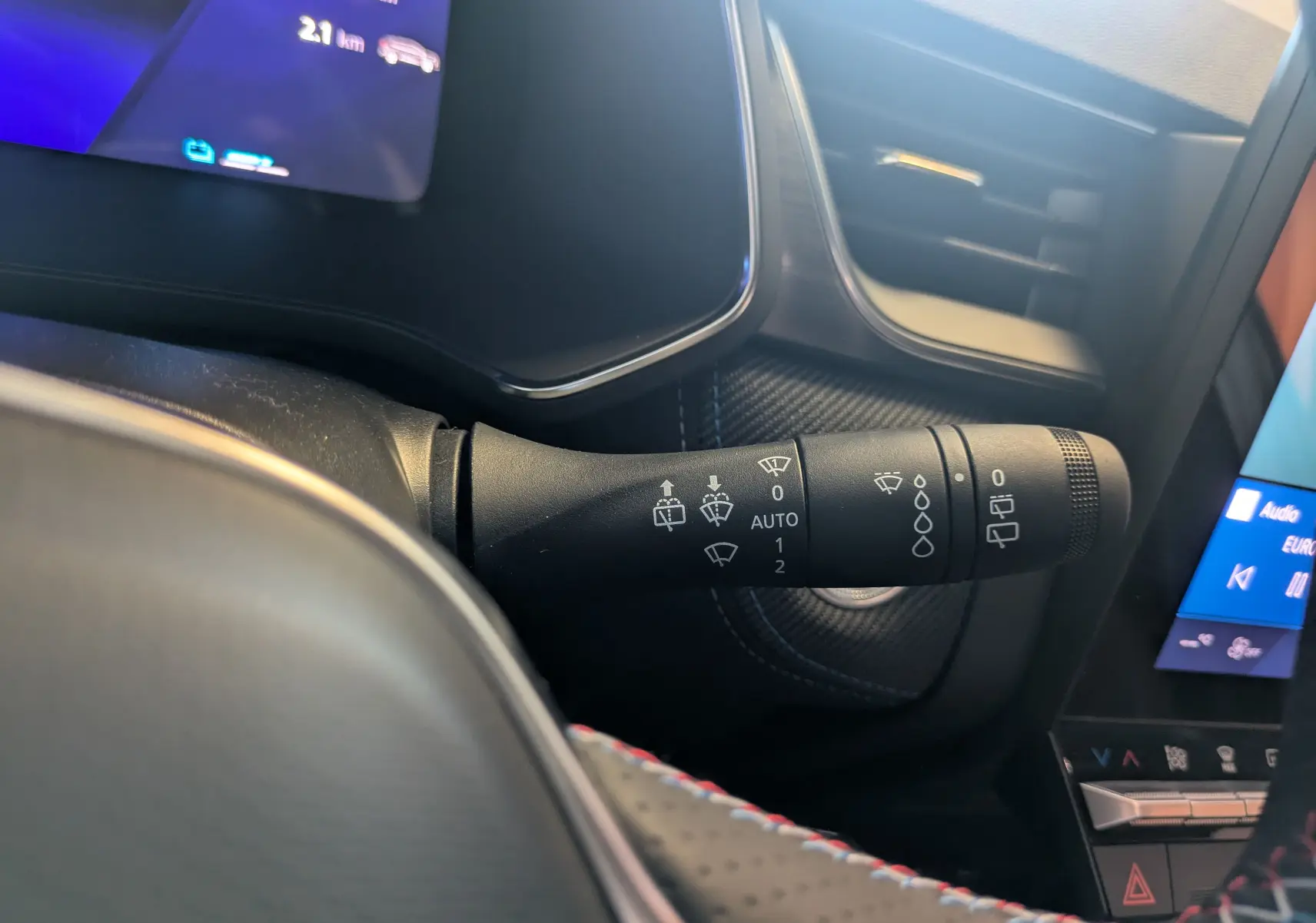 Gros plan sur la commande des essuie-glaces du tableau de bord du Renault Symbioz E-Tech noir, avec écran tactile visible.