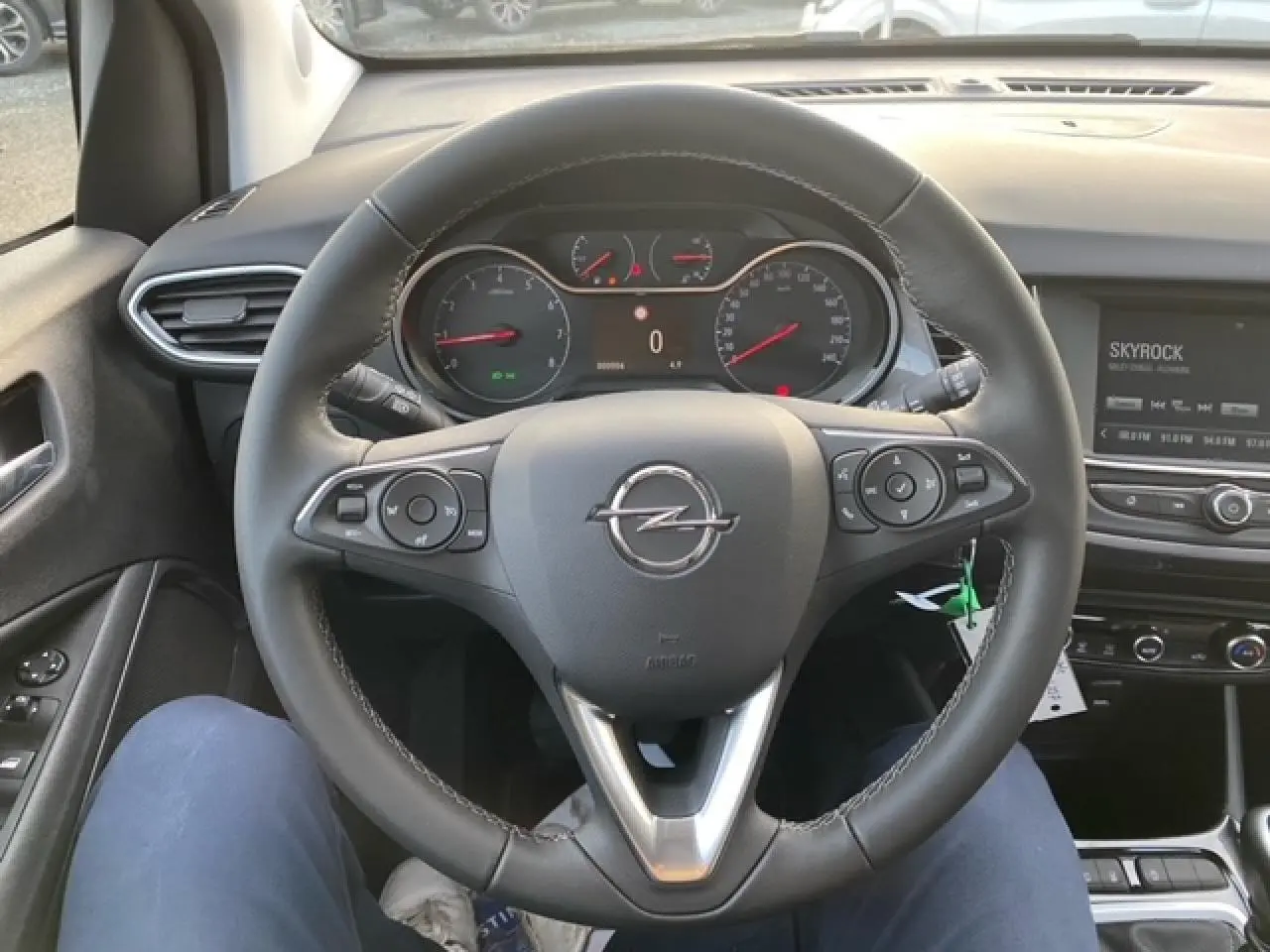 Vue centrée sur le volant cuir noir de l'Opel Crossland 2022, avec tableau de bord et écran multimédia en arrière-plan.