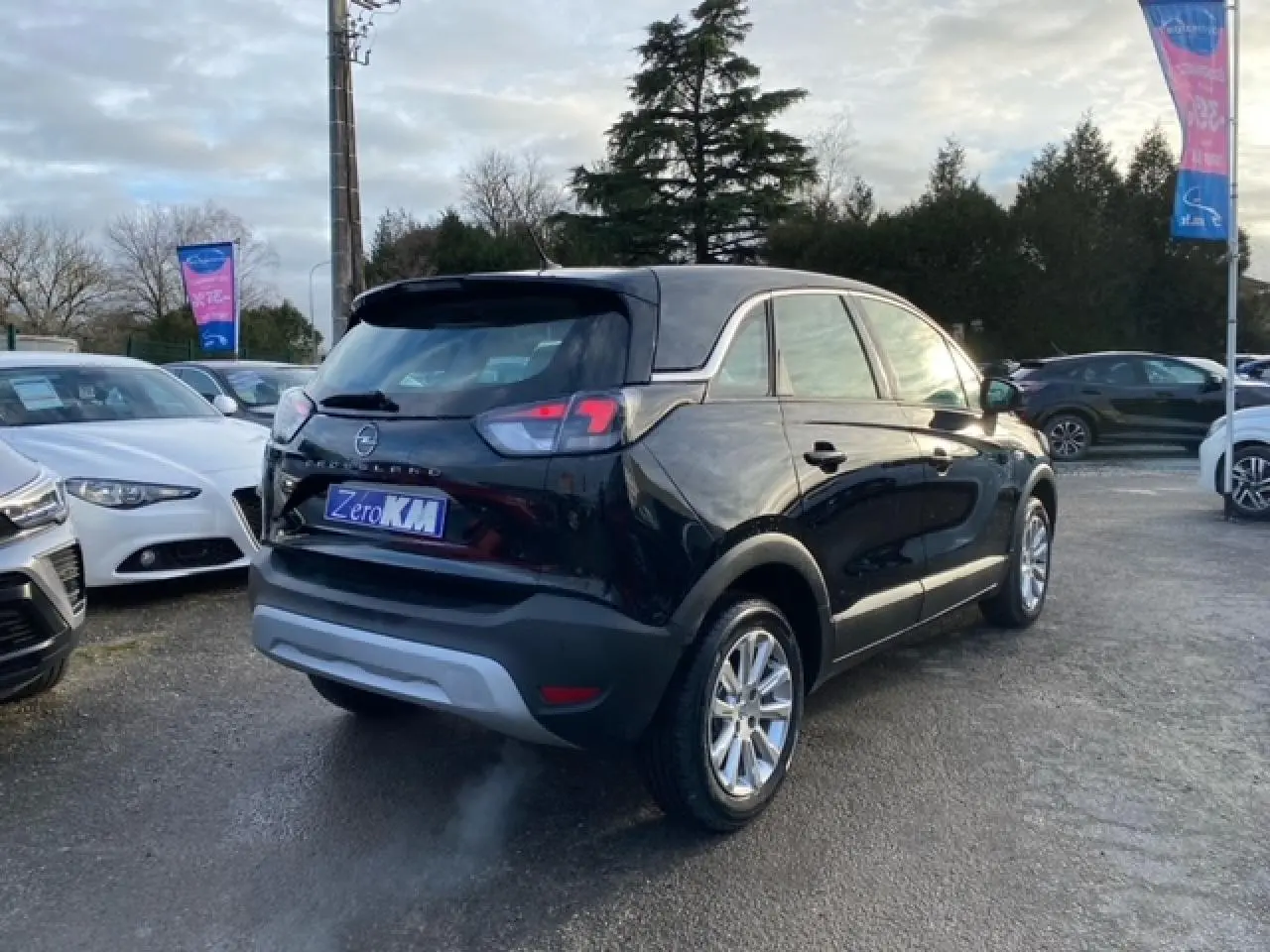 Vue 3/4 arrière droite d'un Opel Crossland noir métal 2022 avec feux arrière halogène et jantes alliage.