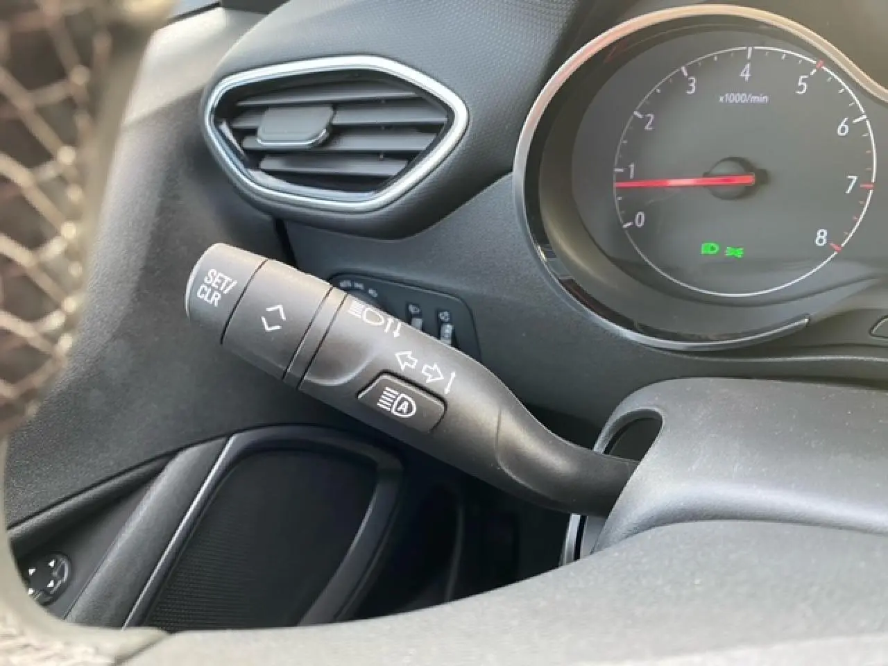 Gros plan sur le commodo gauche et le compte-tours du tableau de bord noir de l'Opel Crossland 2022.